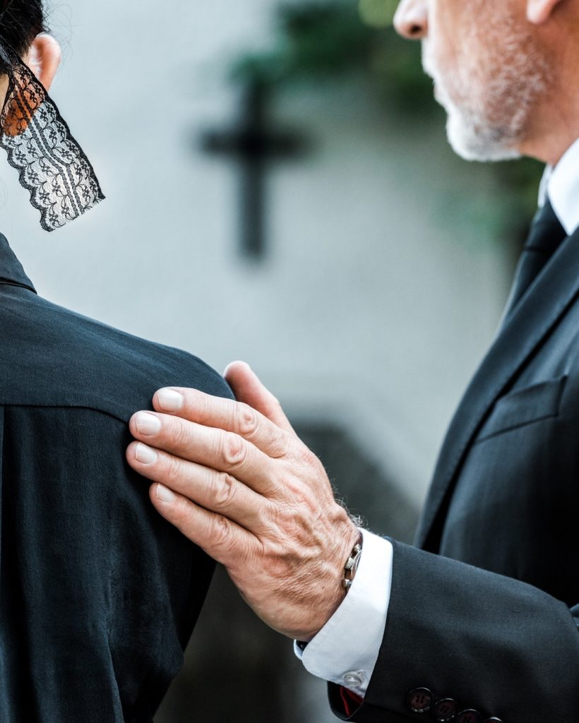 cropped-view-of-man-touching-woman-on-funeral.jpg