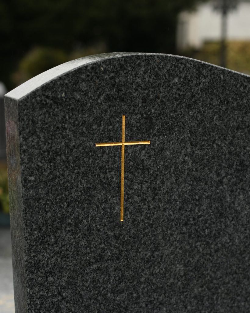Cross on a marble slab on a grave in a cemetery