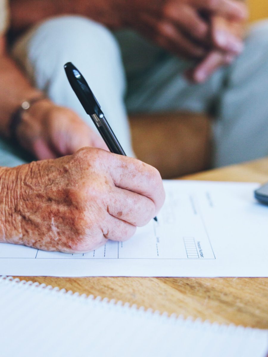 Senior man, paperwork and hands to sign or home for finance, life insurance and planning for assets.