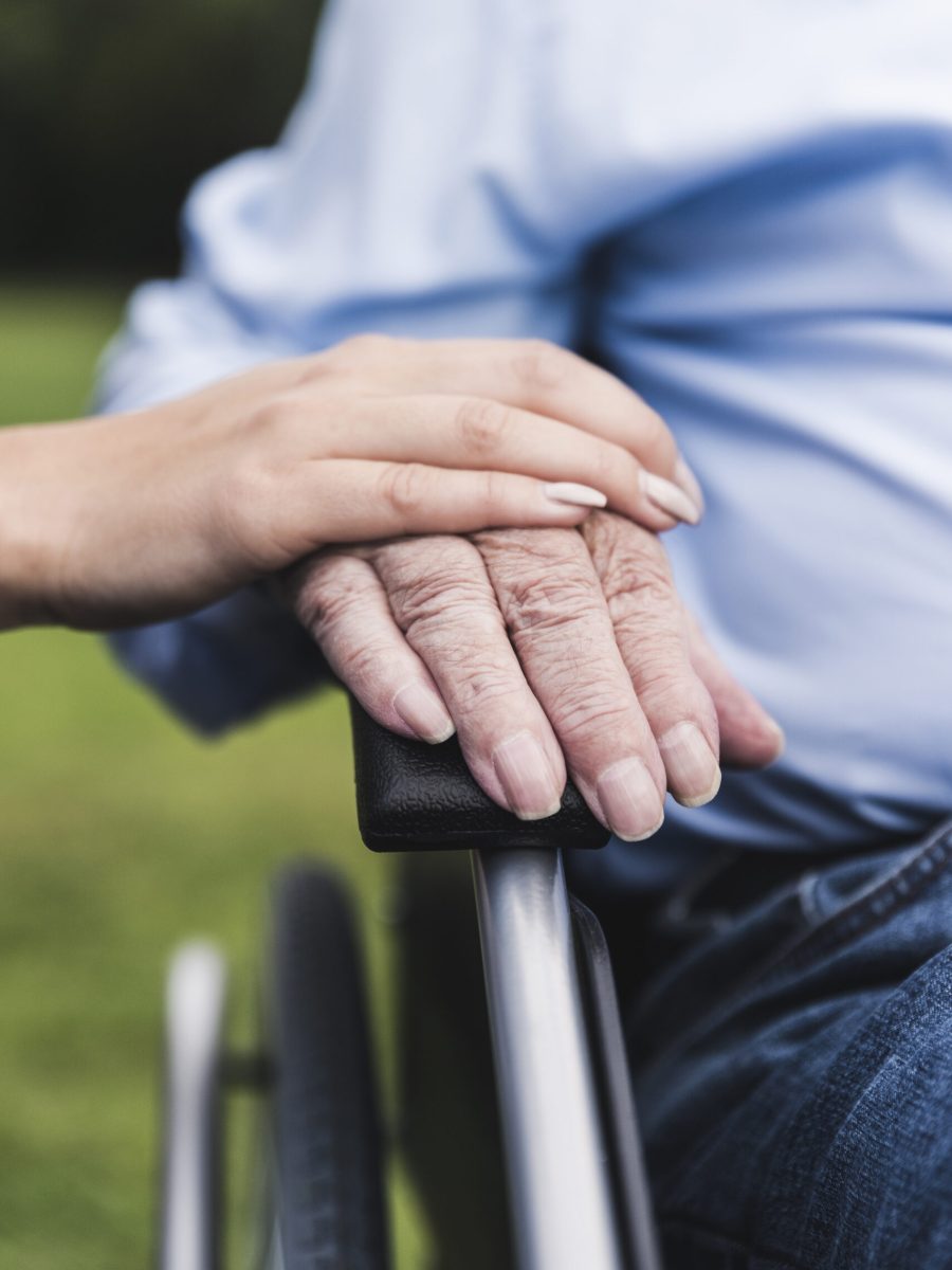 Young woman touching senior man's hand, close-up